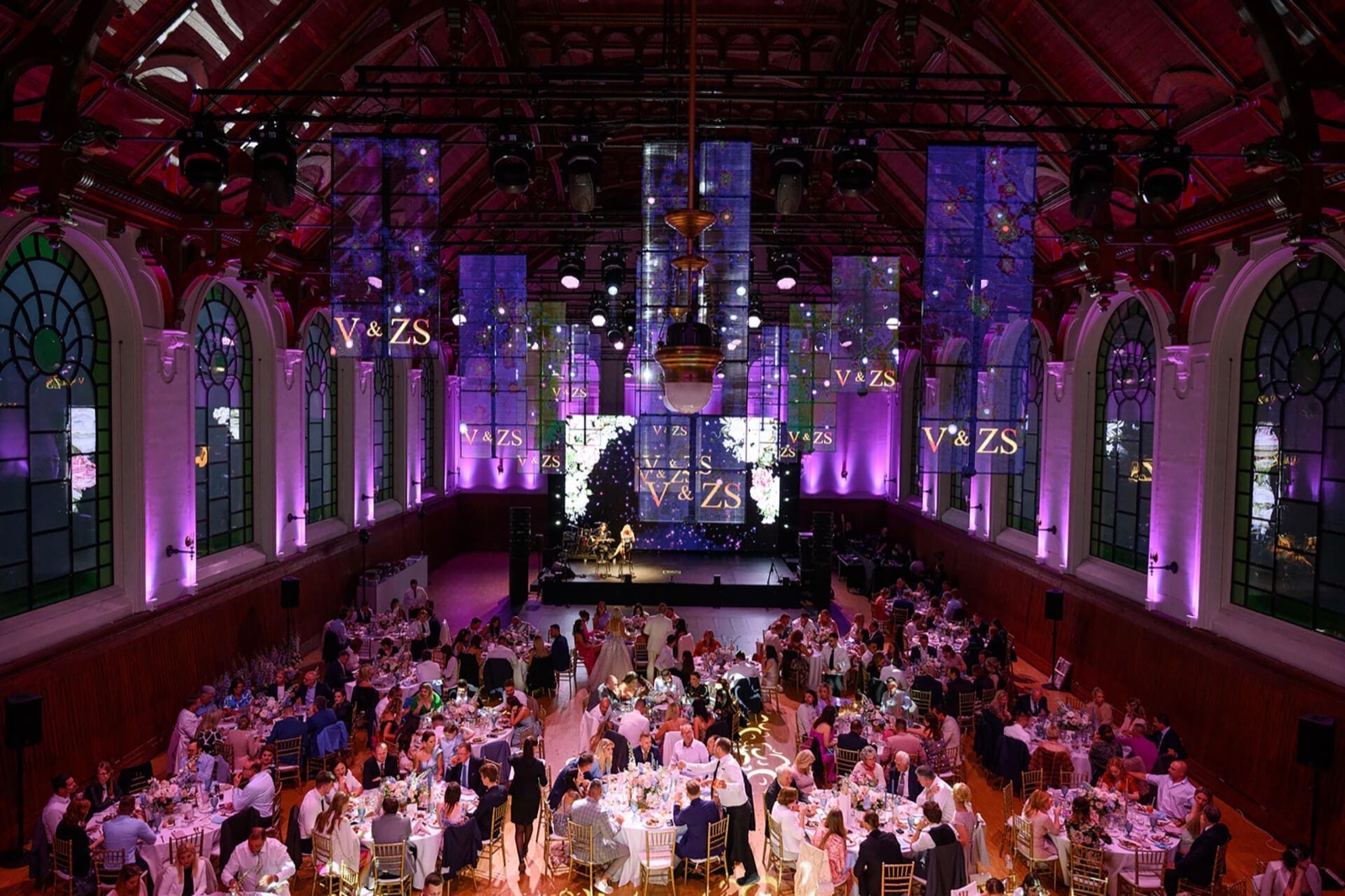 Ballroom during an evening event, with purple lighting and laid tables