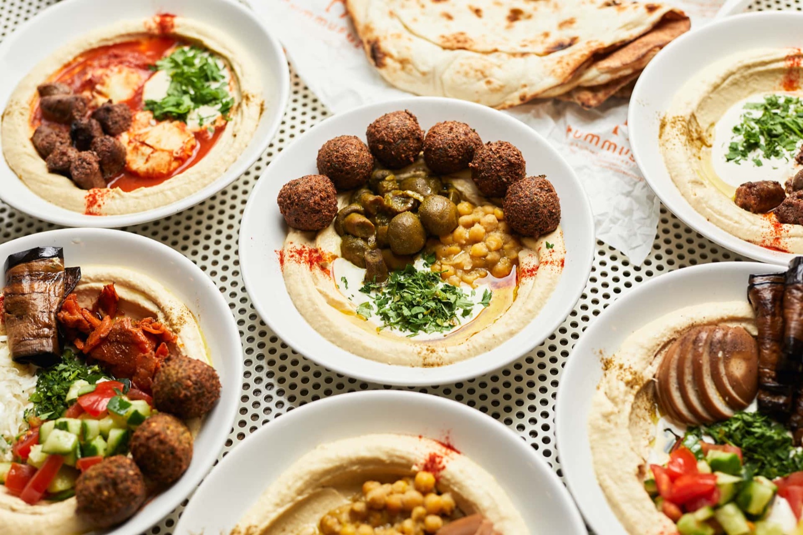 Hummus plates with falafel, pita and fresh vegetables, from above